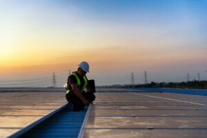Technician checking Photovoltaic cells panels on factory roof
